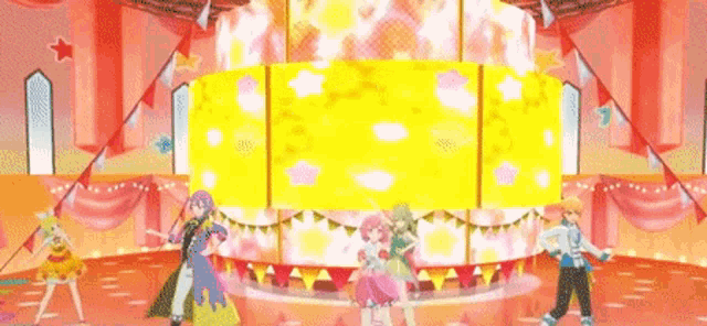 a group of girls are dancing on a stage in front of a large yellow screen .