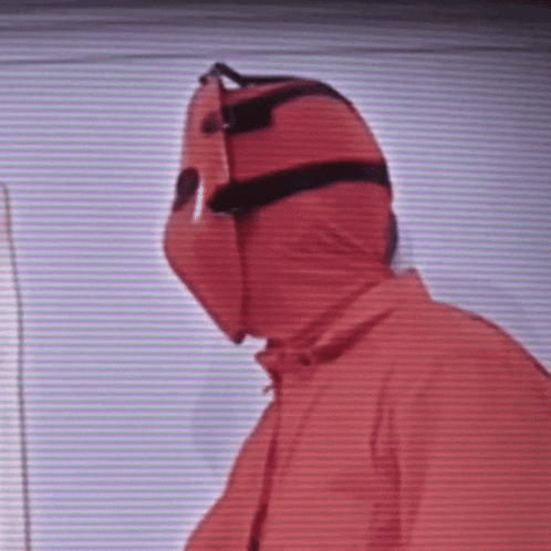 a person wearing a red hooded jacket and a mask