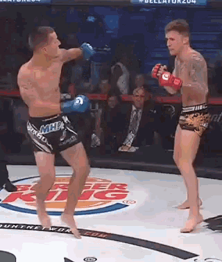 two men are fighting in a boxing ring with a burger king logo on the floor