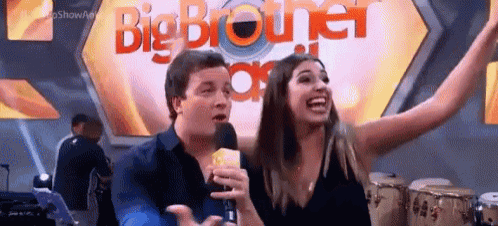 a man and a woman are standing in front of a big brother sign .