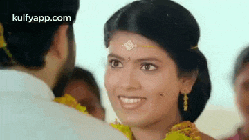 a bride and groom are looking at each other and smiling at each other .