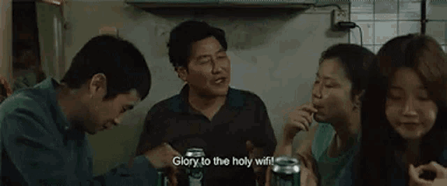 a group of people are sitting around a table holding cans of soda and eating snacks .