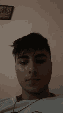 a young man is taking a selfie with headphones in his ear .