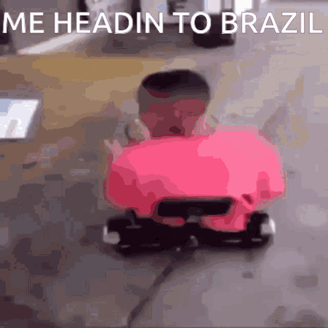 a man in a pink shirt is riding a pink toy car with the words me headin to brazil written on the bottom