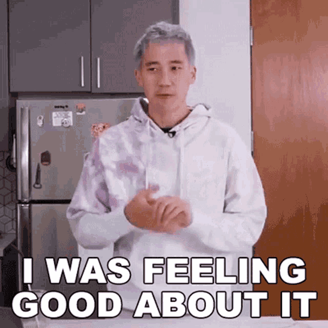 a man in a tie dye hoodie is standing in front of a refrigerator and saying `` i was feeling good about it ''
