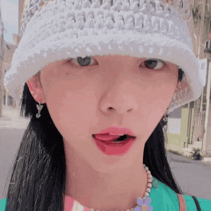a close up of a woman wearing a white hat and a necklace