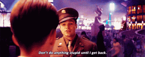 a man in a military uniform is talking to another man in a crowded room .