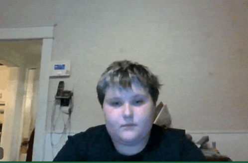 a person 's face is shown in front of a wall with a phone hanging on it