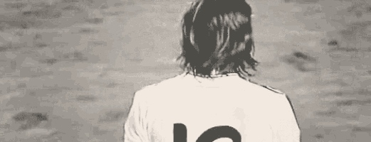 a man with long hair is wearing a white shirt with the number 10 on it .