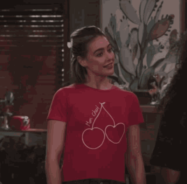 a woman wearing a red t-shirt that says " have a cherry "