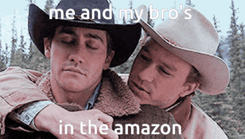 two men in cowboy hats are hugging each other in the woods .