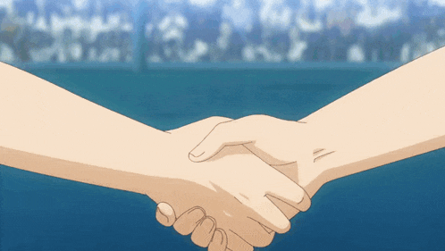 two people shaking hands with a crowd behind them