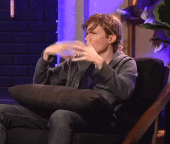 a man is sitting in a chair with his hands on his face