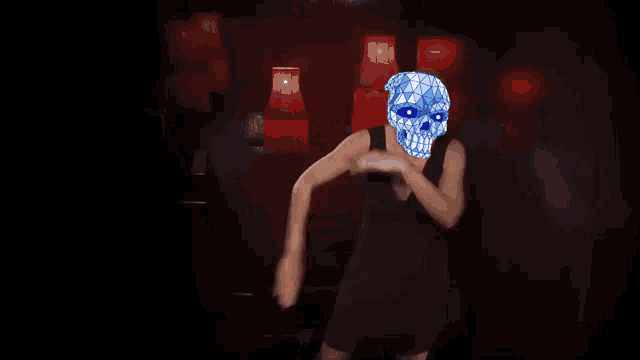a woman in a black dress is dancing with a blue skull on her head