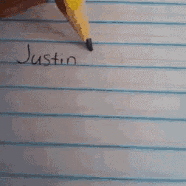 a person writing the name justin bieber on a piece of paper