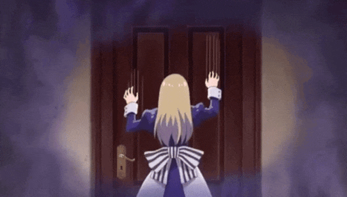 a woman is standing in front of a door with her hands on it .