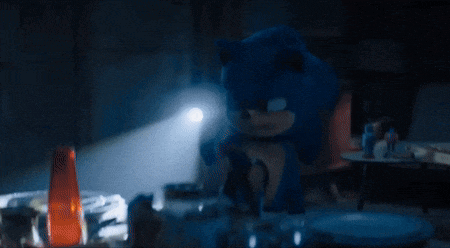 sonic the hedgehog is sitting in a dark room with a light shining on him
