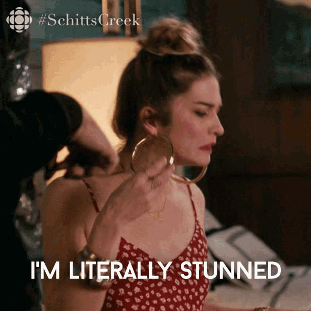 a woman wearing hoop earrings says i 'm literally stunner