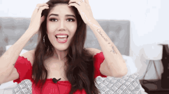 a woman in a red top has a tattoo on her arm that says " camino e amore "