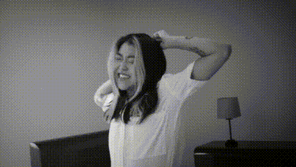 a woman in a white shirt is stretching her arms in a black and white photo .