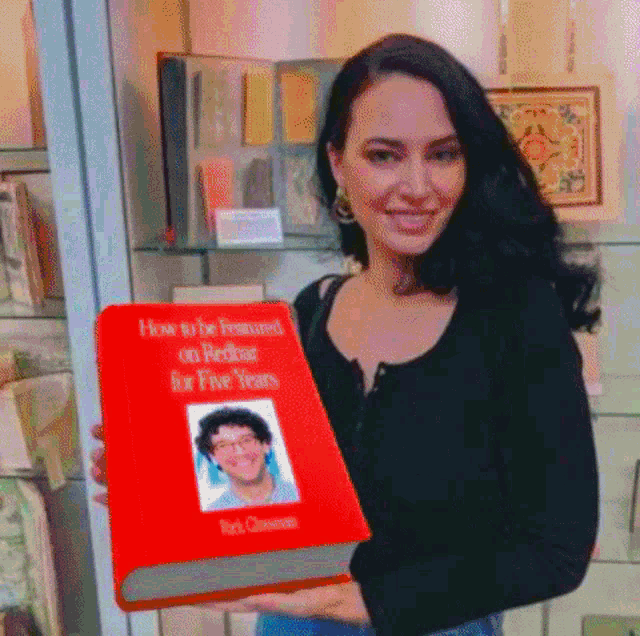 a woman is holding a red book that says how to be featured on redstar for five years