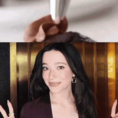 a woman with a ring on her finger is smiling in front of a wall