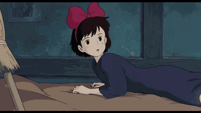 a girl with a red bow on her head is laying on the ground
