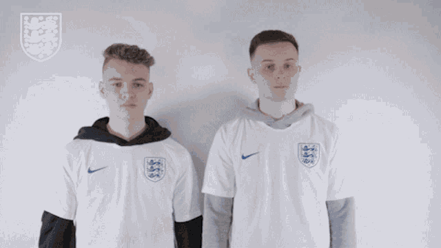 two boys wearing white nike shirts with a lion on the front