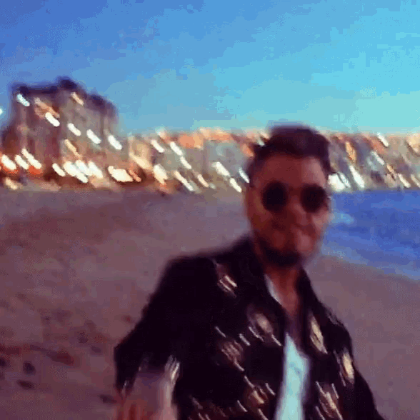a blurry picture of a man walking on a beach
