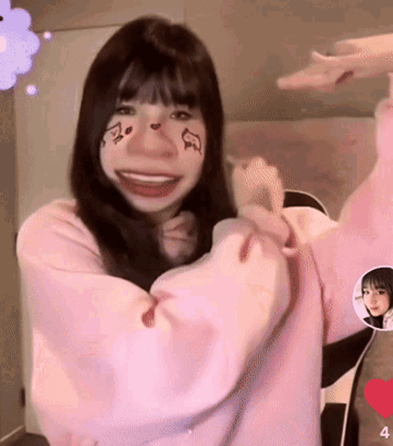 a girl in a pink sweater has a face painted on her face and the number 4 next to her
