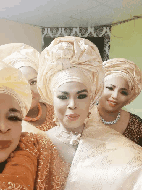 a group of women are posing for a picture and one of them is wearing a turban