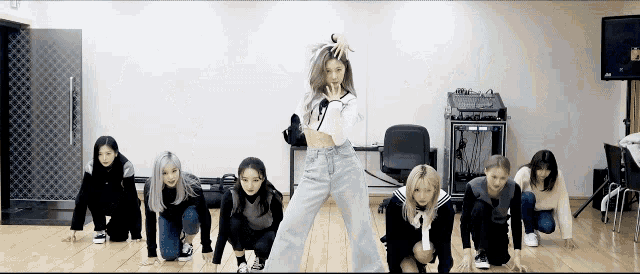 a group of women are kneeling down in a dance studio