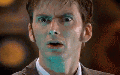 a close up of a man 's face with blue paint on it and a surprised look on his face .