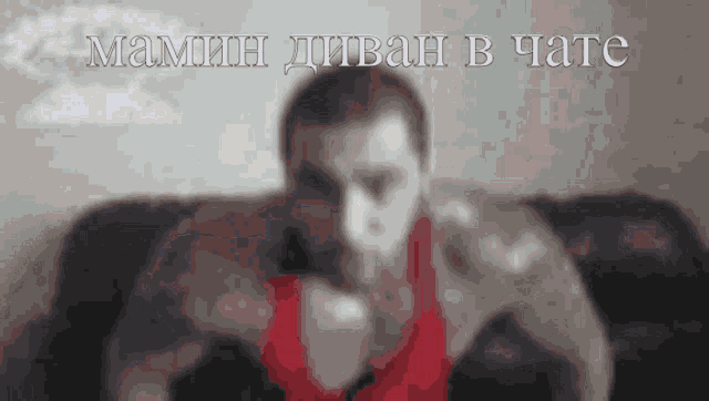 a blurry picture of a man sitting on a couch with the words " mamin divan b tate " written above him