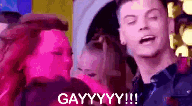 a man with his eyes closed is surrounded by people and says gayyyyy !!!