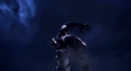 a monster with red wings is standing in front of a city at night