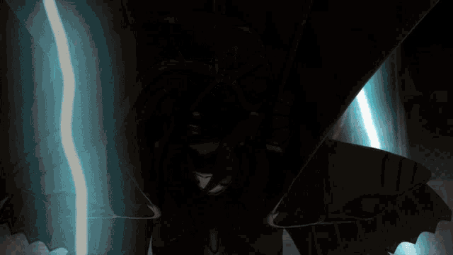 a person in a dark room with a blue light coming out of it