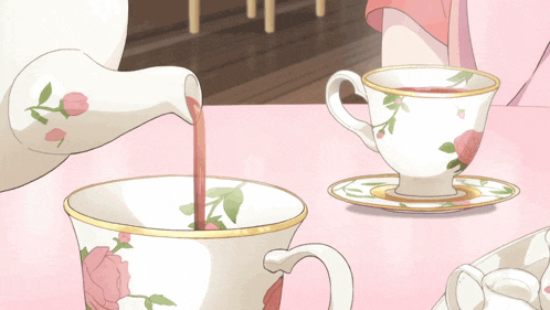 a cup of tea is being poured into another cup