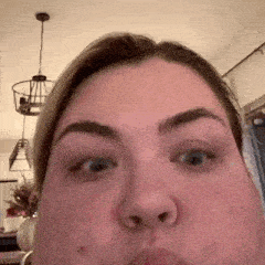 a close up of a woman 's face making a funny face in a living room .