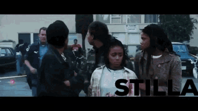 a group of people are standing in front of a building and the word stilla is on the bottom