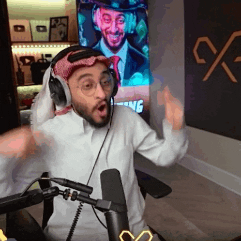 a man wearing headphones is sitting in front of a microphone in a room