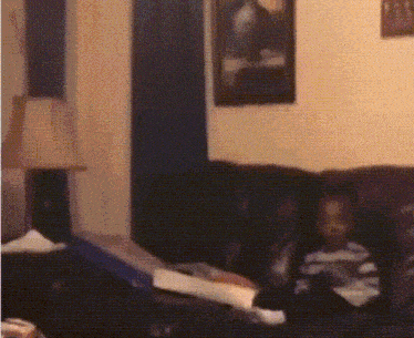 a blurry picture of a living room with a lamp and a picture on the wall
