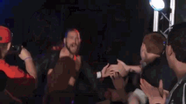 a man with a beard is standing in front of a crowd of people .