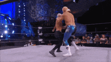 two wrestlers in a ring with the word aew on the ring ropes