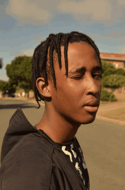 a young man wearing a black hoodie and a black and white shirt