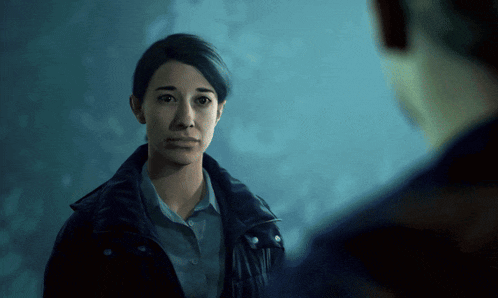 a woman in a black jacket is looking at a man