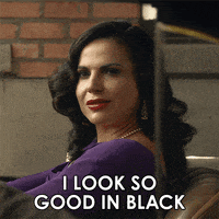 a woman in a purple dress is sitting in a chair and says " i look so good in black "