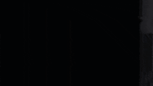a black and red anime girl is peeking out from behind a door .