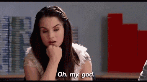 a woman is sitting in a classroom and saying oh my god .