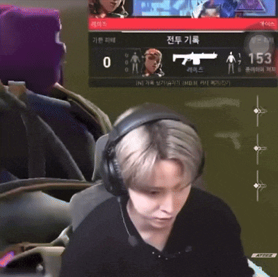 a man wearing headphones is sitting in front of a screen that says 153 on it